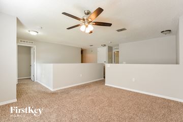 Apopka house for rent - a spacious living room with carpet and a ceiling fan