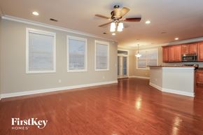 Moncks Corner house for rent - A spacious room with wooden floors and a ceiling fan.