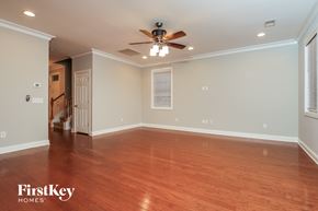 Moncks Corner house for rent - A spacious room with wooden floors and a ceiling fan.