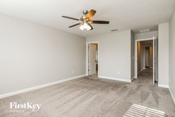 Kissimmee house for rent - a spacious living room with carpet and a ceiling fan