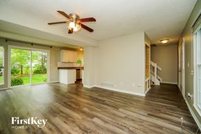 Hilliard house for rent - an empty living room with a ceiling fan and a kitchen