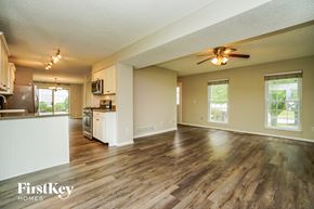 Hilliard house for rent - an empty living room with a kitchen and a ceiling fan