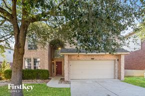 San Antonio house for rent - a brick house with a white garage door and a tree