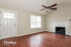 Newnan house for rent - a living room with a fireplace and a ceiling fan