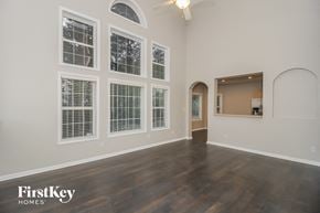 Mableton house for rent - A spacious room with wooden floors and a large arched doorway.