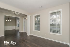 Mableton house for rent - A spacious room with wooden floors and a chandelier.