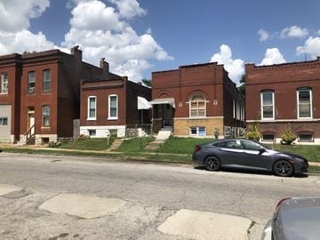 St. Louis house for rent - A grey car is parked on the side of a street.