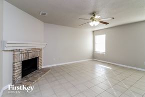 Fort Worth house for rent - A room with a fireplace and a ceiling fan.
