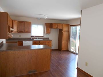 St. Clair Shores house for rent - A kitchen with wooden cabinets and a dark counter top.