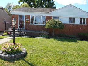 St. Clair Shores house for rent - A house with a white front and a small garden.