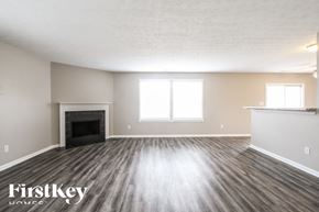 Indianapolis house for rent - A spacious room with a fireplace and wood flooring.