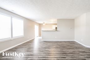 Indianapolis house for rent - A spacious room with wooden flooring and a large window.