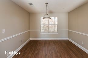 Snellville house for rent - an empty dining room with wood floors and a window