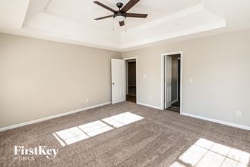 Snellville house for rent - a living room with carpet and a ceiling fan