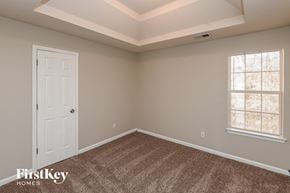 Snellville house for rent - a bedroom with a white door and a carpeted floor