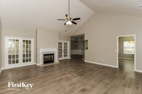 Acworth house for rent - A spacious living room with wood flooring and a fireplace.