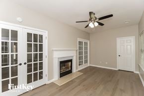 Acworth house for rent - A room with a fireplace and a ceiling fan.