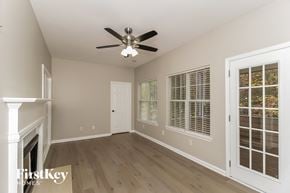 Acworth house for rent - A room with a ceiling fan and a fireplace.