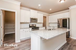 Auburn house for rent - a kitchen with white cabinets and a marble counter top
