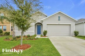 Apopka house for rent - A house with a blue door and a tree in front of it.