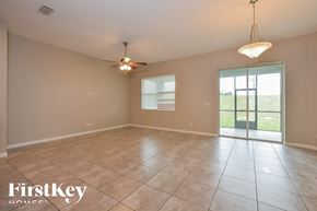 Apopka house for rent - A spacious room with a ceiling fan and sliding glass doors leading to a grassy area.