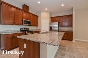Apopka house for rent - A kitchen with a granite countertop and wooden cabinets.