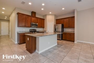 Apopka house for rent - A kitchen with brown cabinets and a white island.