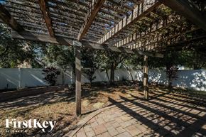 Orlando house for rent - a pergola over a brick patio with trees