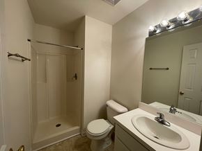 Wilson apartment for rent - A bathroom with a toilet, sink, and shower.