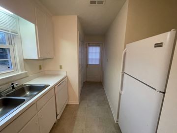 Wilson apartment for rent - A kitchen with white cabinets and a white refrigerator.