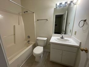 Wilson apartment for rent - A white bathroom with a toilet, sink, and bathtub.