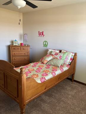 Lincoln house for rent - A bedroom with a bed, dresser, and ceiling fan.