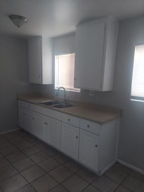 San Bernardino apartment for rent - an empty kitchen with white cabinets and a sink