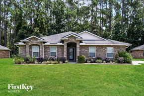 Jacksonville house for rent - A house with a well-manicured lawn and trees in the background.