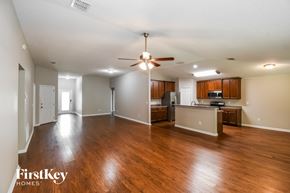 Jacksonville house for rent - A spacious living room with wood flooring and a ceiling fan.