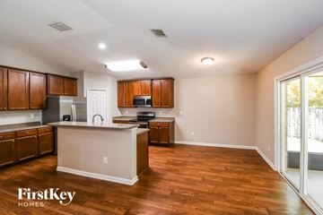 Jacksonville house for rent - A kitchen with wooden cabinets and a white island.