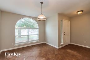 Conroe house for rent - an empty dining room with a large window and a door