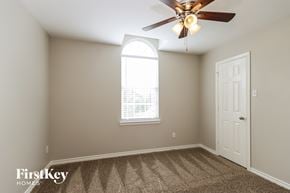 Conroe house for rent - a bedroom with a ceiling fan and a window