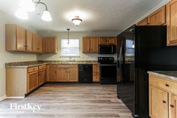 Indianapolis house for rent - a kitchen with wooden cabinets and black appliances