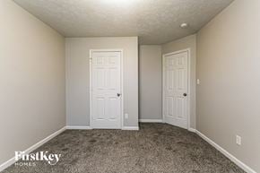 Indianapolis house for rent - a bedroom with two doors and a carpeted floor