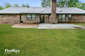 Bartlett house for rent - a small brick house with a grassy yard and a porch