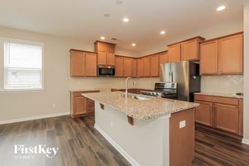 Charlotte house for rent - A kitchen with wooden cabinets and a granite countertop.