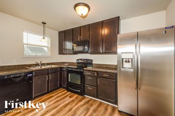 Lake St Louis house for rent - A kitchen with a stainless steel refrigerator and wooden floors.