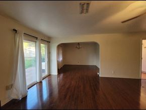 Temple house for rent - an empty living room with hard wood floors and white walls