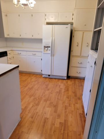 Temple house for rent - a kitchen with a wooden floor and white cabinets