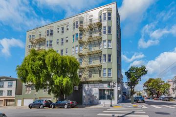 San Francisco apartment for rent - A large building with a green facade and a staircase on the side.