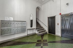 San Francisco apartment for rent - A hallway with a staircase, mailboxes, and doors.