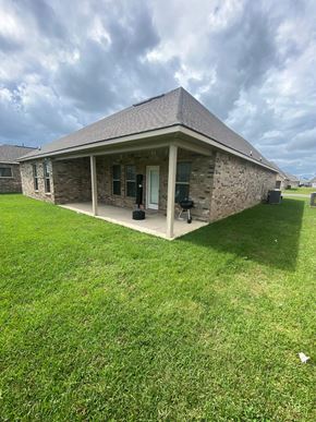 Maurice house for rent - a stone house with a porch and a grass yard
