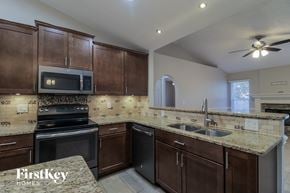 Cocoa house for rent - a kitchen with granite counter tops and wooden cabinets