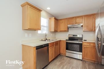 Charlotte house for rent - a kitchen with wooden cabinets and stainless steel appliances